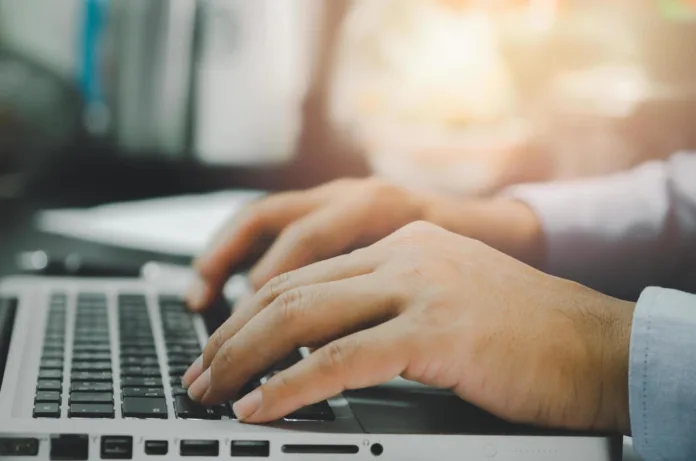 man-hand-using-computer-laptop-on-table-at-home-free-photo